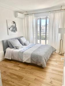 1 dormitorio con cama y ventana grande en Majestic Apartment, en Cannes