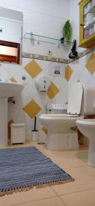 ein Badezimmer mit 2 WCs und einem Waschbecken in der Unterkunft Ti Laura Praia in Praia da Barra