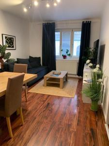 ウィーンにあるComfort Humboldt Apartmentのリビングルーム(青いソファ、テーブル付)