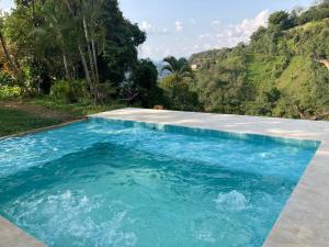 una piscina de agua azul frente a una montaña en Finca Jaragual, en La Vega