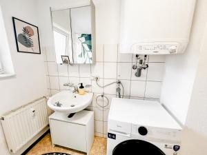 baño pequeño con lavabo y lavadora en Gemütliche Stadtwohnung I City Centre en Ulm