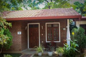 a small red brick house with a red door at So-J Beach Villa in Trincomalee +90 photos