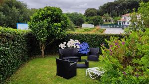 a garden with two chairs and a vase of flowers at Apartamento con jardín in Barro de Llanes +8 photos