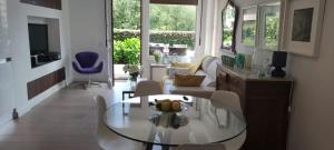 a living room with a glass table and chairs at Apartamento con jardín in Barro de Llanes