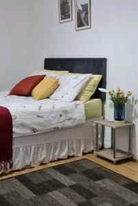 łóżko z żółtymi i czerwonymi poduszkami i stołem w obiekcie Serene Double Room w Londynie