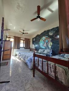 a bedroom with two beds and a ceiling fan at Suítes Independentes Praia dos Anjos in Arraial do Cabo