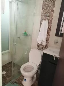 Un baño con inodoro y ducha de cristal. en Finca Hotel Mesopotamia, en Restrepo