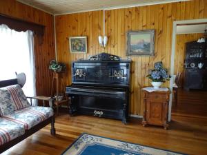 a living room with a piano and a couch at La Posada del Colono in Puerto Clocker