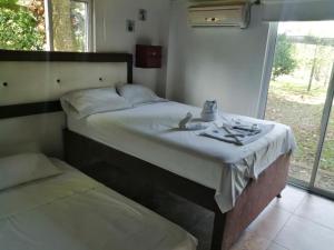 1 dormitorio con 2 camas, mesa y ventana en Finca Hotel Mesopotamia, en Restrepo