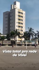 um edifício na praia com um cavalo na praia em DE FRENTE PRO MAR na Praia Grande