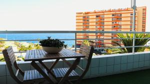 a table and chairs on a balcony with a view of the ocean at Apartamento Armonía in Candelaria