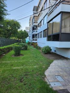 a building with a grass yard next to a building at Viña Excelente, 1 cuadra Av Sn Martin y la playa in Viña del Mar