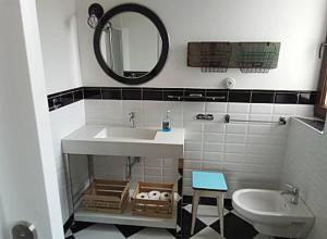 a bathroom with a sink and a toilet and a mirror at Casa vacacional en Prío (Unquera) in Prío