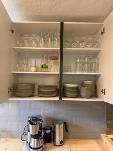 une cuisine avec des assiettes et des verres sur les étagères dans l'établissement Ferienhaus Hemann mit eigener Sauna, à Tellerhäuser
