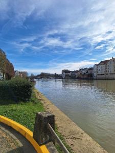 een rivier met gebouwen aan de zijkant bij Appartement standing proche Disney et Paris in Pomponne