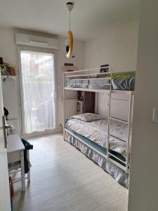 een slaapkamer met 2 stapelbedden en een raam bij Appartement standing proche Disney et Paris in Pomponne
