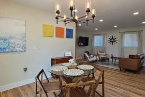 uma sala de jantar e sala de estar com mesa e cadeiras em Beachside Bliss: Chic Family Home 3BR Oasis w/Great Amenities Walk to the Waves! em Imperial Beach