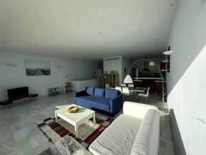 un soggiorno con divano blu e tavolo di Casamar a Almería