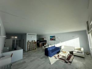 a living room with a blue couch and a table at Casamar in Almería