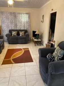a living room with two couches and a rug at Fairmont in Negril