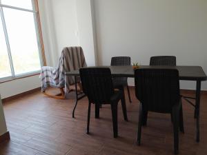 une salle à manger avec quatre chaises et une table dans l'établissement El Departamento de Ethan en Asia, à Asia