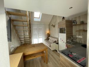 cocina pequeña y sala de estar con escalera de caracol en Risoul 1850 Beau Duplex pour 6 pers en plein centre de la station, en Risoul