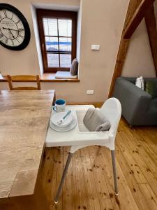 ein Wohnzimmer mit einem weißen Tisch und einer Uhr in der Unterkunft Holiday home Hůrka in Hurka