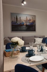 Apartament Wenecja في غروجونتس: طاولة غرفة الطعام مع إناء من الزهور عليها