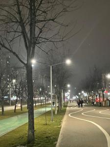 a city street at night with people walking down the street at Premium new Apartament in Chişinău