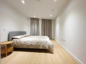 a bedroom with a bed and a table in it at Modern apartment in heart area in London