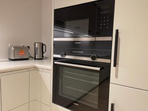 a black microwave oven in a kitchen at Modern apartment in heart area in London