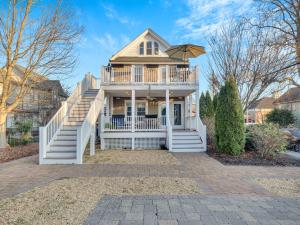 a large white house with a deck and stairs at The Savannah, Boutique BNB & Spa in Lewes