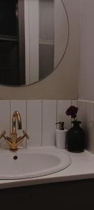 La salle de bains est pourvue d'un lavabo, d'un robinet et d'un miroir. dans l'établissement Aparthotel Nowy Świat 28, à Varsovie