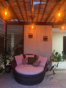 - un grand canapé en osier installé sur une terrasse dans l'établissement Quarto Casal, Wi-Fi, Piscina, Praia, à Vila Velha