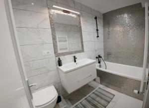 a bathroom with a toilet and a sink and a tub at Oasului Residence in Cluj-Napoca +71 photos