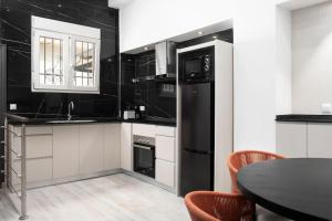 une cuisine avec des appareils en noir et blanc et une table dans l'établissement Modern 1-Bed Apartment with Wi-Fi, à Torremolinos