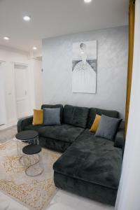 a living room with a green couch and a table at Oasului Residence in Cluj-Napoca