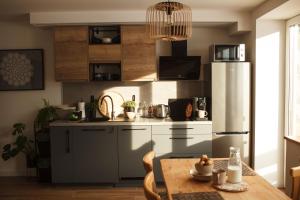 a kitchen with a refrigerator and a wooden table at Aleksandria nad Olzą in Istebna