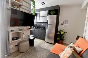 a living room with a refrigerator and a kitchen at Rua Paim - garagem, ar condicionado e piscina in Sao Paulo
