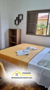 ein Zimmer mit einem Bett und einem Handtuch darauf in der Unterkunft Pousada Integração Buritizal in Buritizal