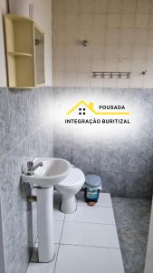 a bathroom with a sink and a toilet at Pousada Integração Buritizal in Buritizal