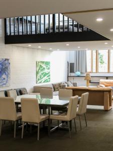 uma sala de estar com uma mesa e cadeiras e um sofá em Large Bright Modern Loft Apt - Central Location - Suitable for Families and Groups em Narrabundah