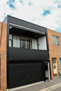 um edifício com uma porta de garagem preta em Large Bright Modern Loft Apt - Central Location - Suitable for Families and Groups em Narrabundah