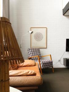 uma sala de estar com um sofá e uma cadeira em Large Bright Modern Loft Apt - Central Location - Suitable for Families and Groups em Narrabundah