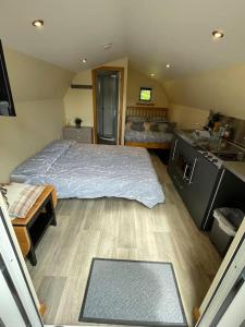 a bedroom with a large bed and a kitchen at Morvan Pod in Fort William