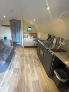 a bedroom with a bed and a kitchen with a sink at Morvan Pod in Fort William