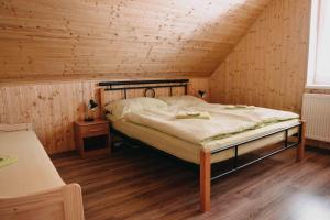 Na Bučinské في كفيلدا: غرفة نوم بسرير في غرفة خشبية