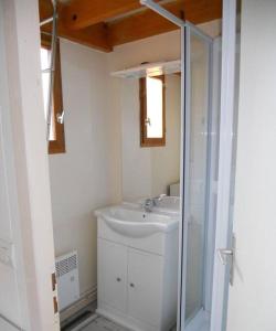 Un baño con lavabo y ducha de cristal. en Maison dans parc résidentiel de loisirs - V08700, en Soulac-sur-Mer