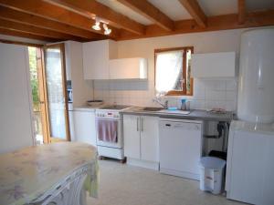 Una cocina con electrodomésticos blancos y una mesa en ella. en Maison dans parc résidentiel de loisirs - V08700, en Soulac-sur-Mer