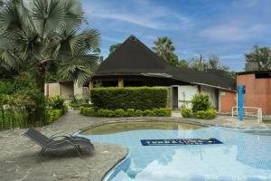 a swimming pool with a chair and a house at Terra Luna Lodge in Tena